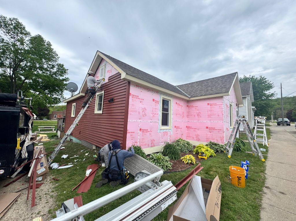 Pink house exterior renovation with workers